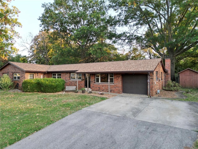 single story home with a storage shed, a front lawn, and a garage