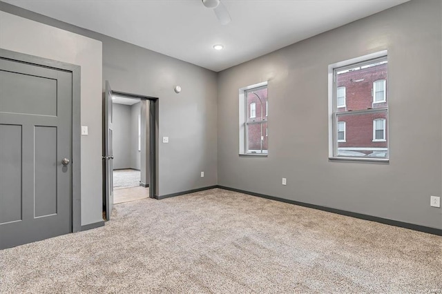 interior space with ceiling fan and light carpet