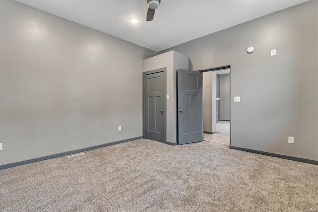 unfurnished bedroom with ceiling fan and light colored carpet