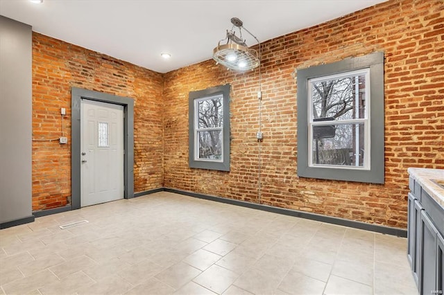 interior space with brick wall and a wealth of natural light