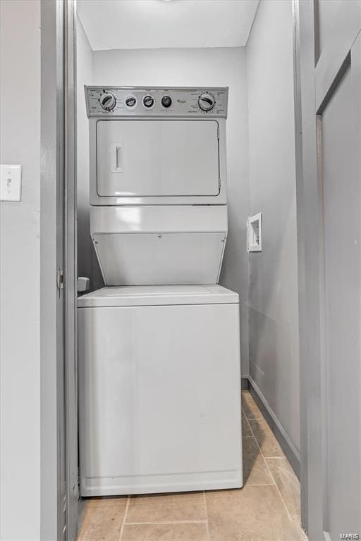 washroom featuring light tile patterned floors and stacked washer and dryer