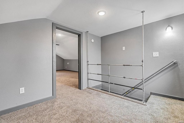 hall featuring light colored carpet and vaulted ceiling