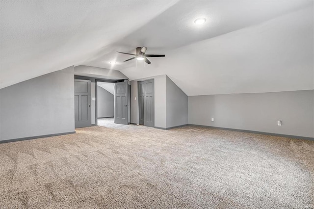 bonus room with light carpet, vaulted ceiling, and ceiling fan