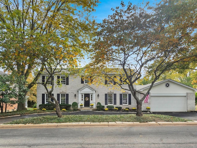 view of front of property with driveway, brick siding, and an attached garage