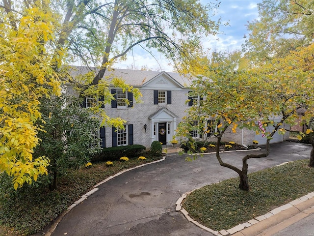 view of front of home with driveway and brick siding