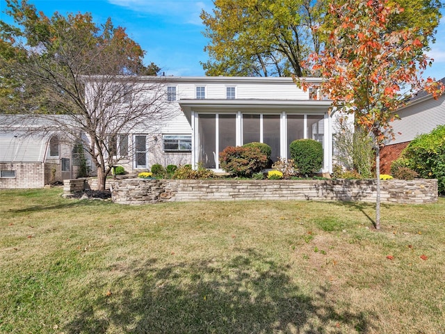 back of house featuring a yard and a sunroom