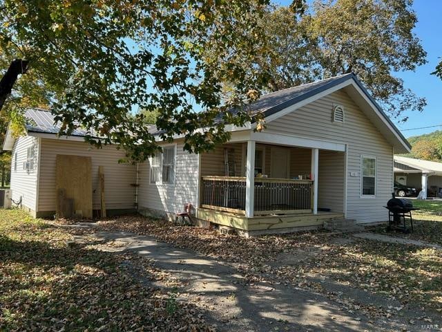 exterior space with a porch and cooling unit