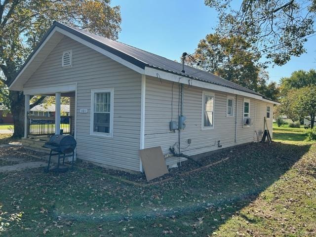 view of side of home with a yard