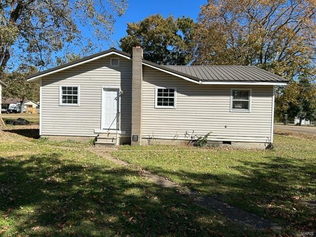 rear view of house featuring a yard