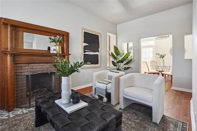 living room featuring dark hardwood / wood-style floors and a brick fireplace