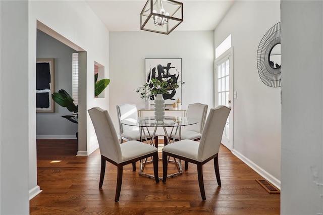 dining area featuring a chandelier and dark hardwood / wood-style flooring