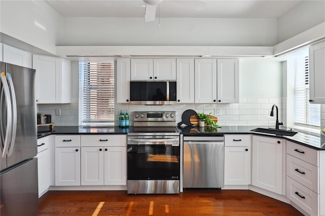 kitchen featuring stainless steel appliances, white cabinetry, tasteful backsplash, and sink