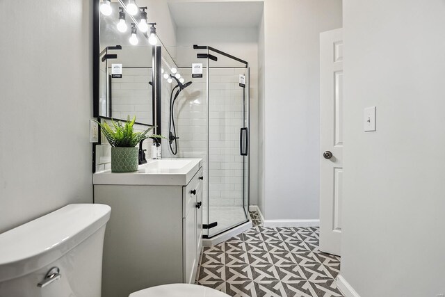 bathroom featuring tile patterned floors, a shower with door, vanity, and toilet