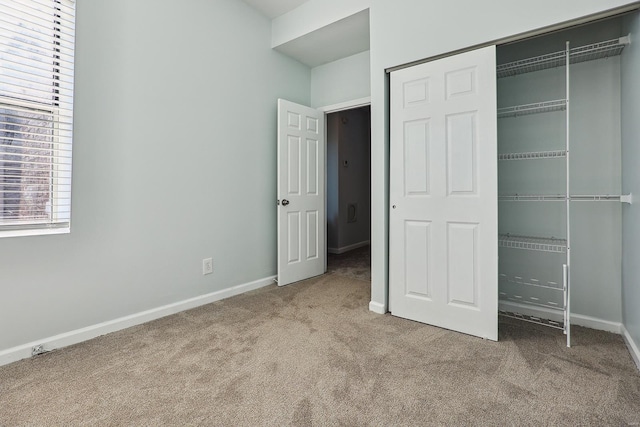 unfurnished bedroom with light carpet and a closet