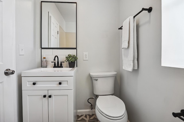 bathroom with decorative backsplash, vanity, and toilet