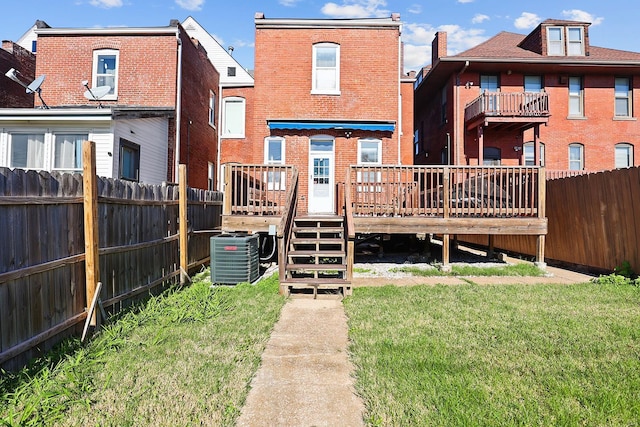 rear view of house featuring a lawn, a wooden deck, and central AC unit