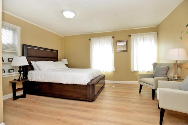 bedroom with crown molding and light hardwood / wood-style floors