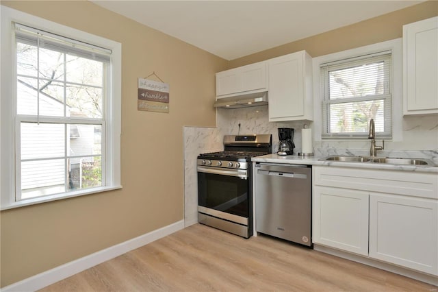 kitchen with appliances with stainless steel finishes, a healthy amount of sunlight, and sink