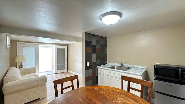 kitchen featuring white cabinetry, sink, and light hardwood / wood-style flooring