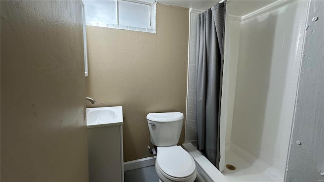 bathroom featuring vanity, walk in shower, and toilet