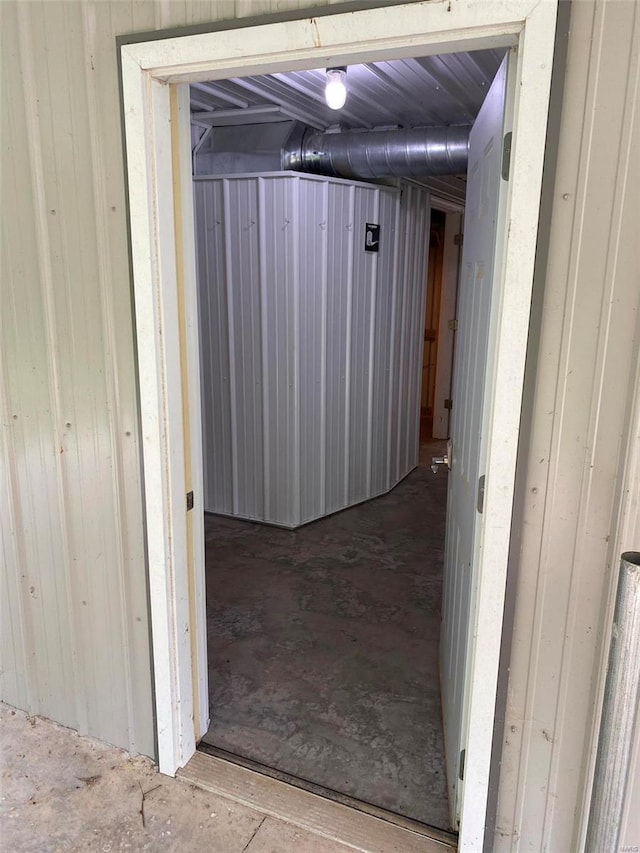 hallway featuring wooden walls