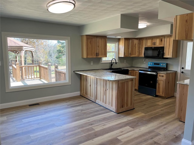 kitchen featuring sink, black appliances, kitchen peninsula, and light hardwood / wood-style flooring