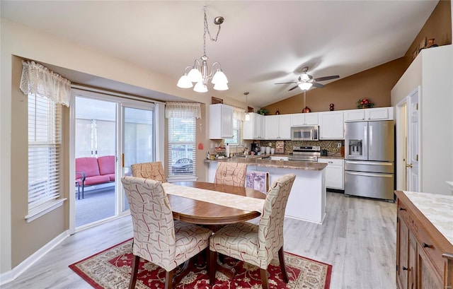 dining room featuring sink, light hardwood / wood-style floors, lofted ceiling, and ceiling fan with notable chandelier