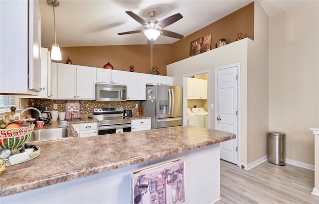 kitchen featuring stainless steel appliances, sink, decorative light fixtures, separate washer and dryer, and white cabinets