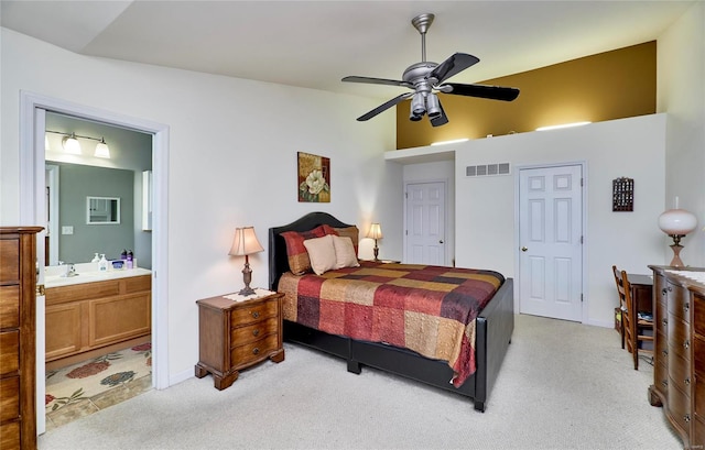 bedroom featuring ensuite bath, lofted ceiling, light colored carpet, and ceiling fan