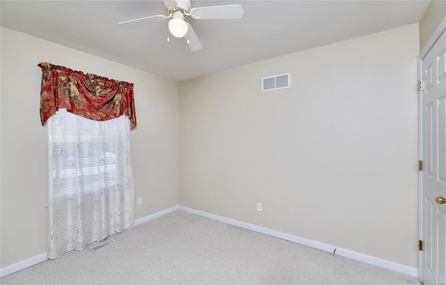 spare room featuring light carpet and ceiling fan