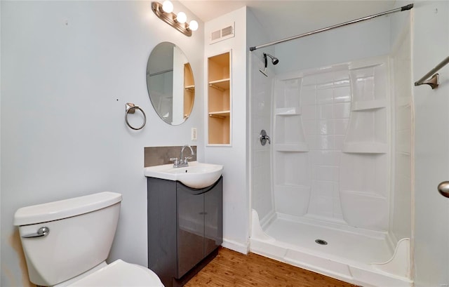 bathroom featuring vanity, a shower, wood-type flooring, and toilet