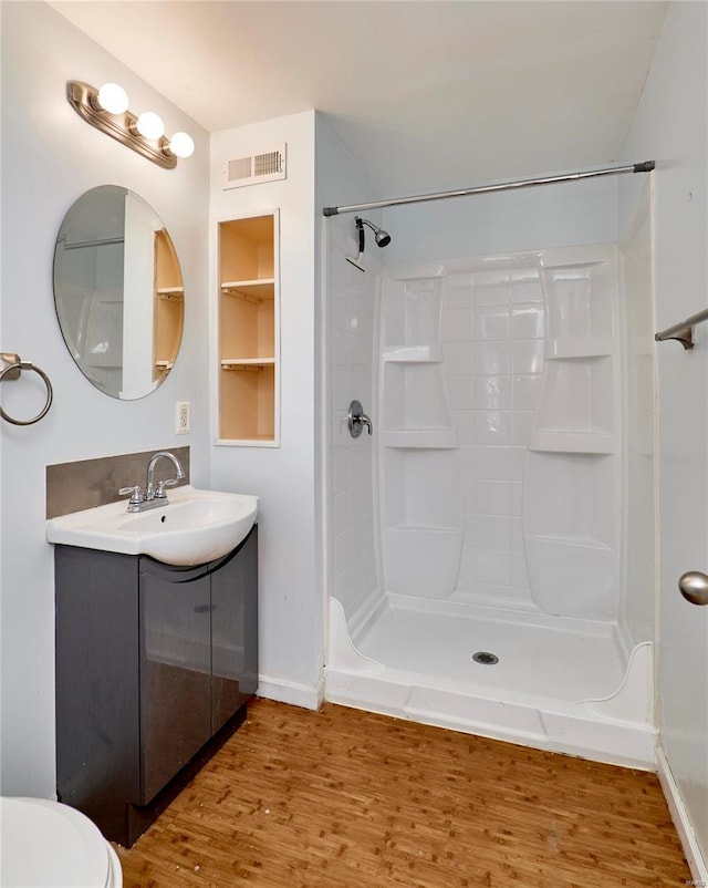 bathroom with vanity, toilet, a shower, and wood-type flooring