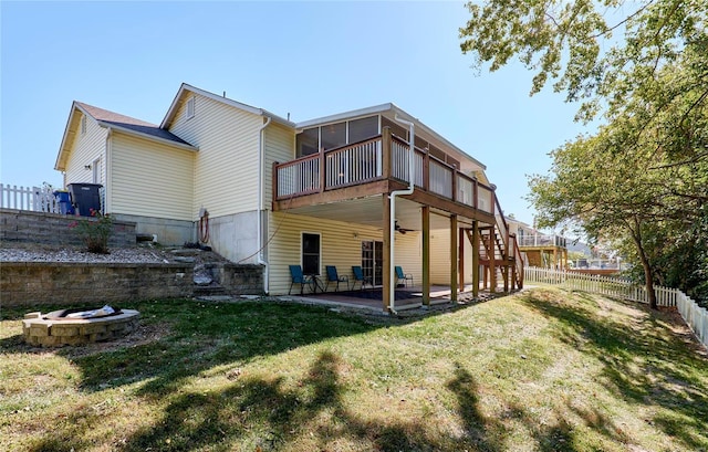 back of property featuring a yard, a deck, a patio area, and a fire pit