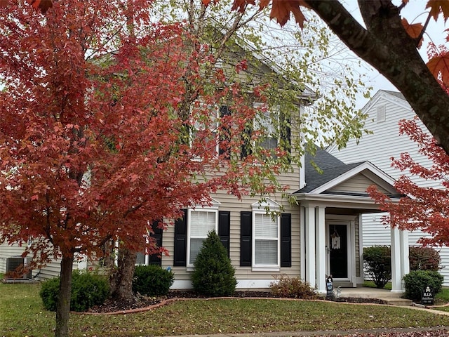 view of property hidden behind natural elements featuring a front yard