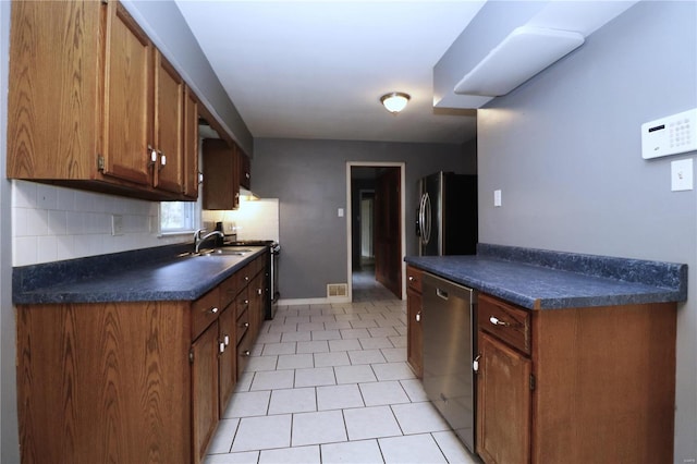 kitchen featuring sink, stainless steel appliances, and backsplash