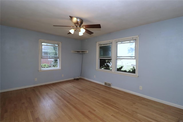 spare room with ceiling fan, light hardwood / wood-style floors, and a healthy amount of sunlight