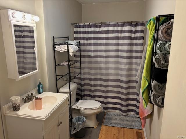 bathroom with vanity, toilet, and wood-type flooring