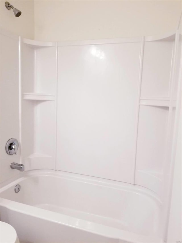 bathroom featuring toilet and bathing tub / shower combination