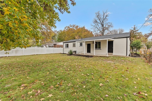 rear view of property with a yard and ceiling fan