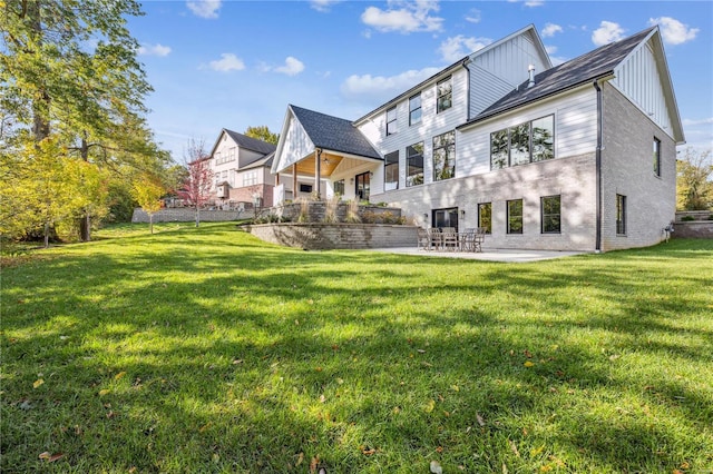 back of house featuring a patio area and a lawn