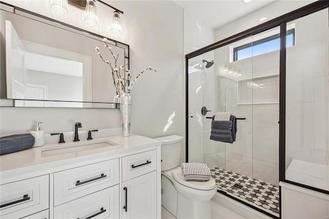 bathroom with toilet, vanity, and a shower with door