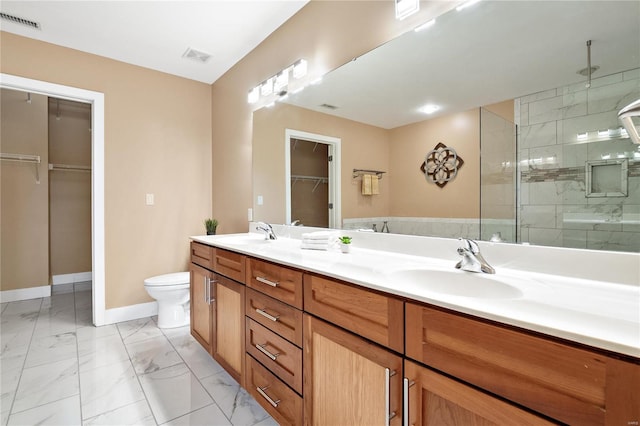 bathroom with a shower with shower door, vanity, and toilet