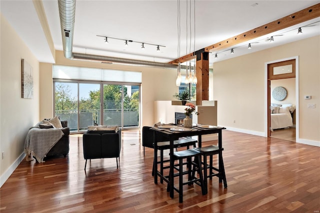 dining area with track lighting and wood-type flooring