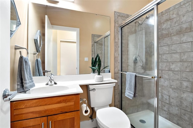 bathroom with vanity, toilet, and a shower with door