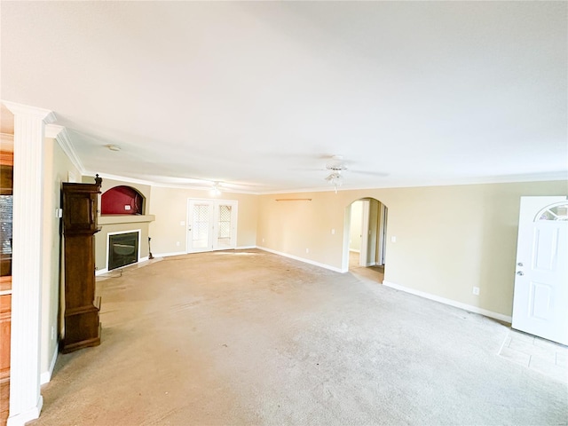 unfurnished living room with ornamental molding, ceiling fan, and light colored carpet