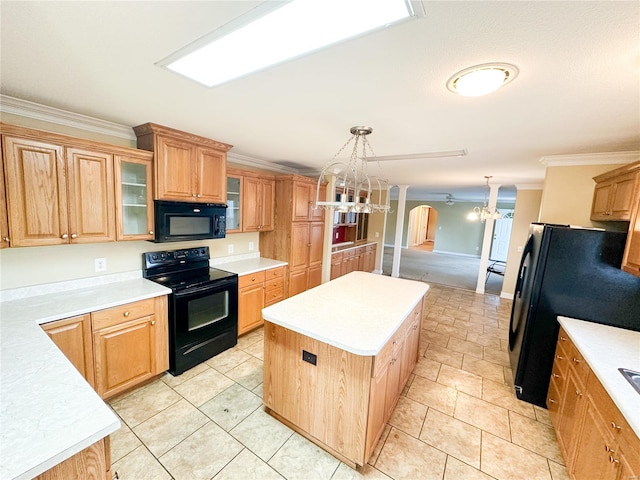 kitchen featuring an inviting chandelier, pendant lighting, ornamental molding, black appliances, and a center island