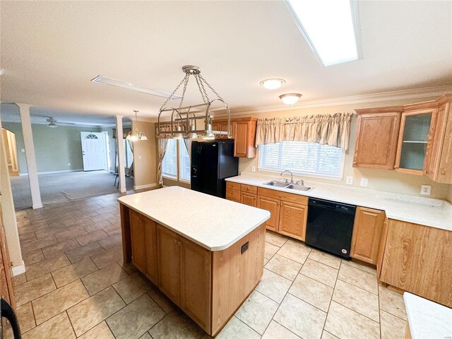 kitchen with a kitchen island, black appliances, sink, crown molding, and decorative light fixtures