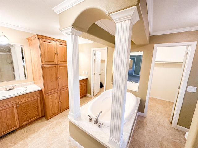 bathroom featuring ornate columns, a bathtub, crown molding, and vanity