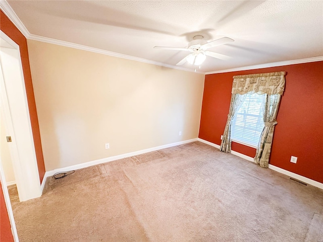 carpeted empty room featuring ornamental molding, ceiling fan, and a textured ceiling