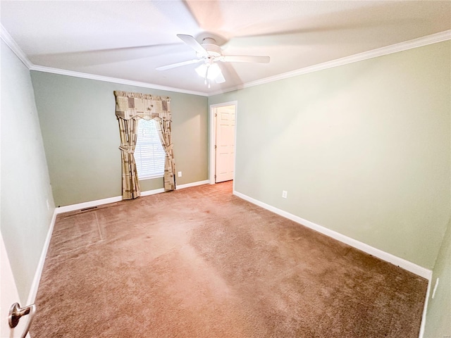 empty room featuring ceiling fan, ornamental molding, and carpet flooring